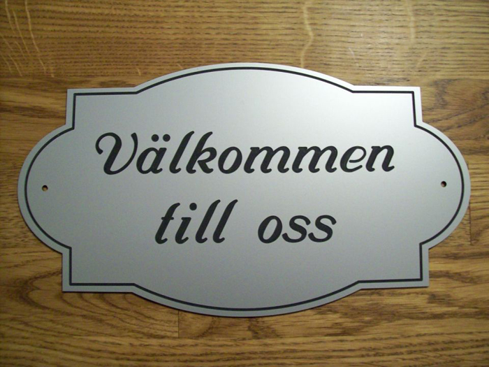 Dörrskylt med texten Välkommen till oss